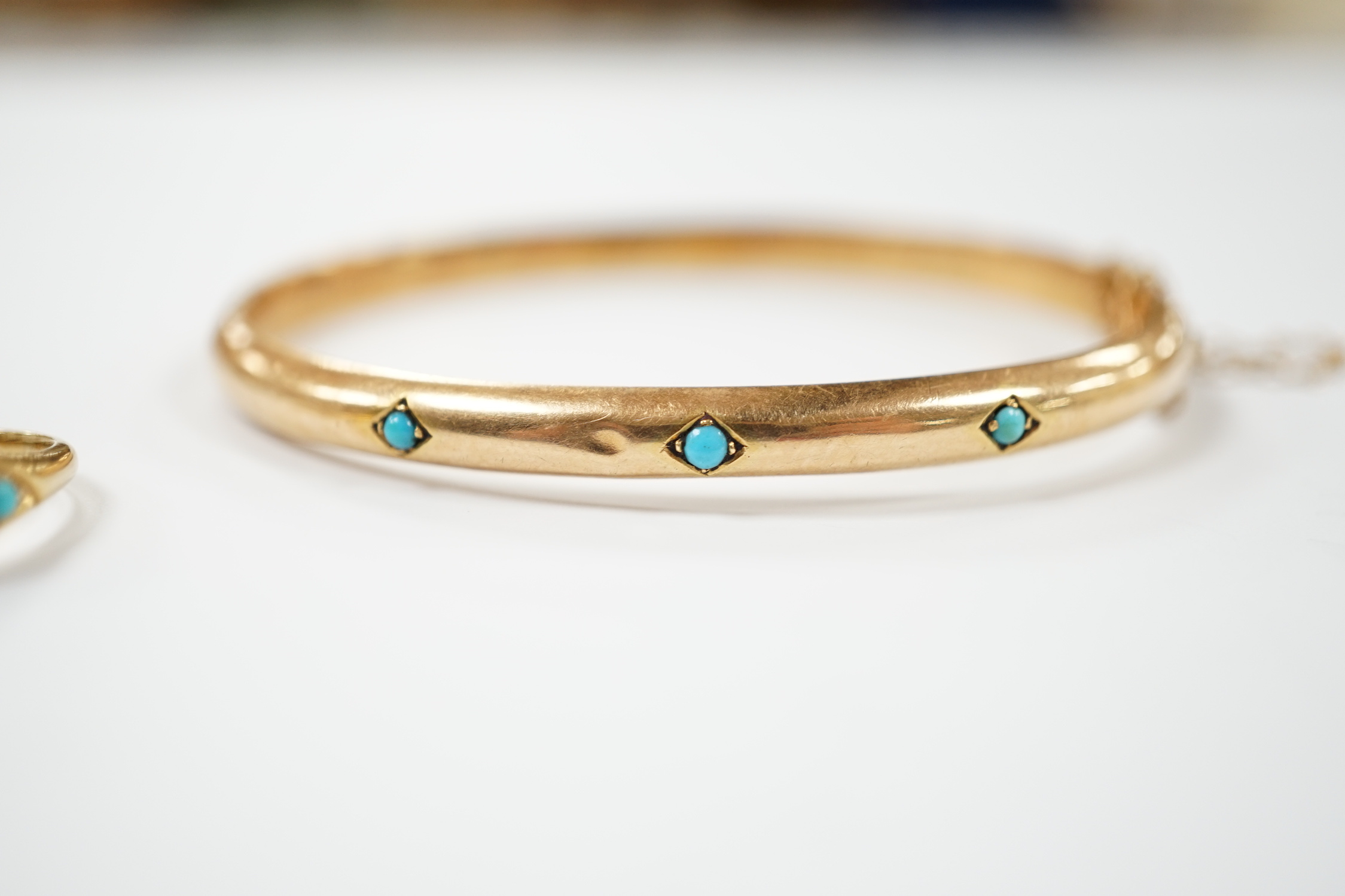 A Victorian yellow metal and three stone cabochon turquoise set hinged bangle, together with a similar yellow metal turquoise and diamond chip cluster set ring, gross weight 10.9 grams.